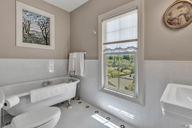 bathroom with sink, tile walls, a washtub, tile patterned floors, and toilet