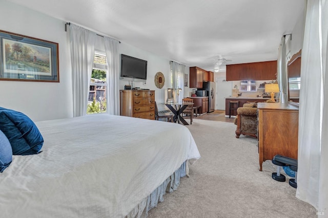 bedroom with stainless steel fridge and light carpet