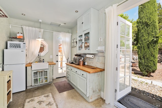 kitchen featuring a wealth of natural light, white cabinetry, and white refrigerator