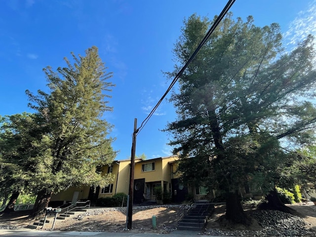 view of front of house featuring stairs and stucco siding