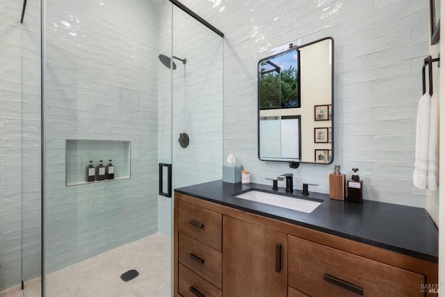 bathroom with vanity, a shower with shower door, and decorative backsplash