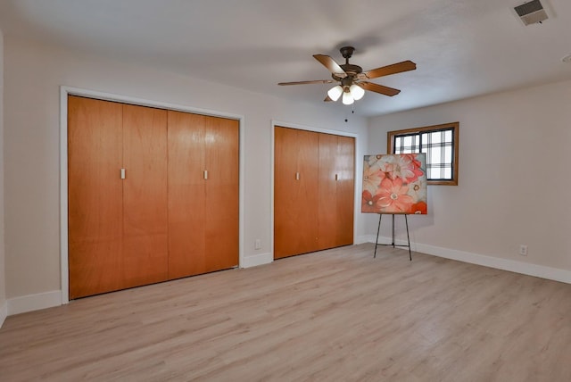 14090 Pine St, Walnut Grove, CA 95690 - unfurnished bedroom with multiple closets, wood finished floors, and ceiling fan