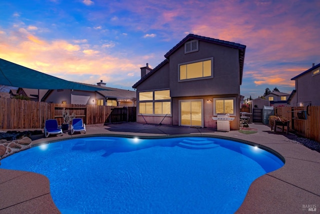 pool at dusk with a patio