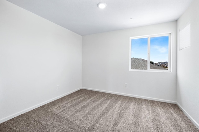 carpeted spare room featuring baseboards