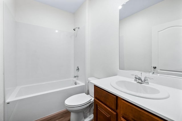 full bathroom with wood finished floors, tub / shower combination, vanity, and toilet