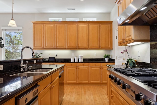 kitchen with extractor fan, pendant lighting, sink, stainless steel gas cooktop, and dark stone counters