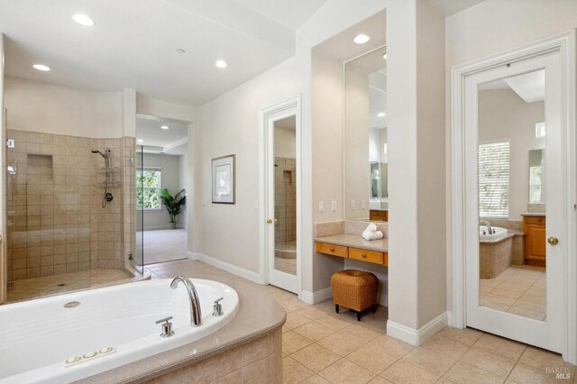 bathroom with tile patterned flooring, separate shower and tub, and vanity