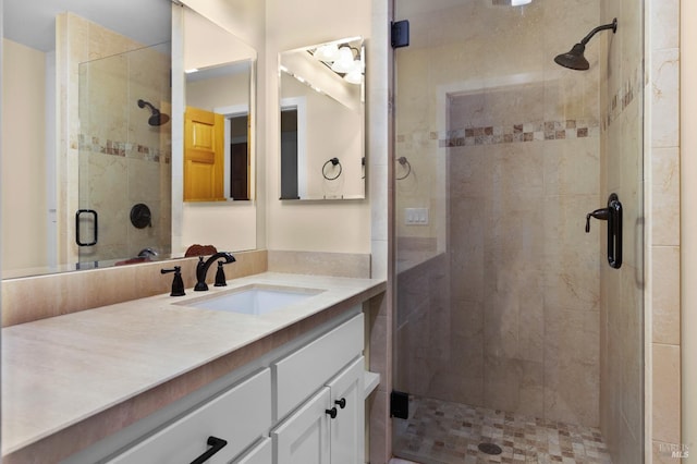 bathroom with a shower stall and vanity