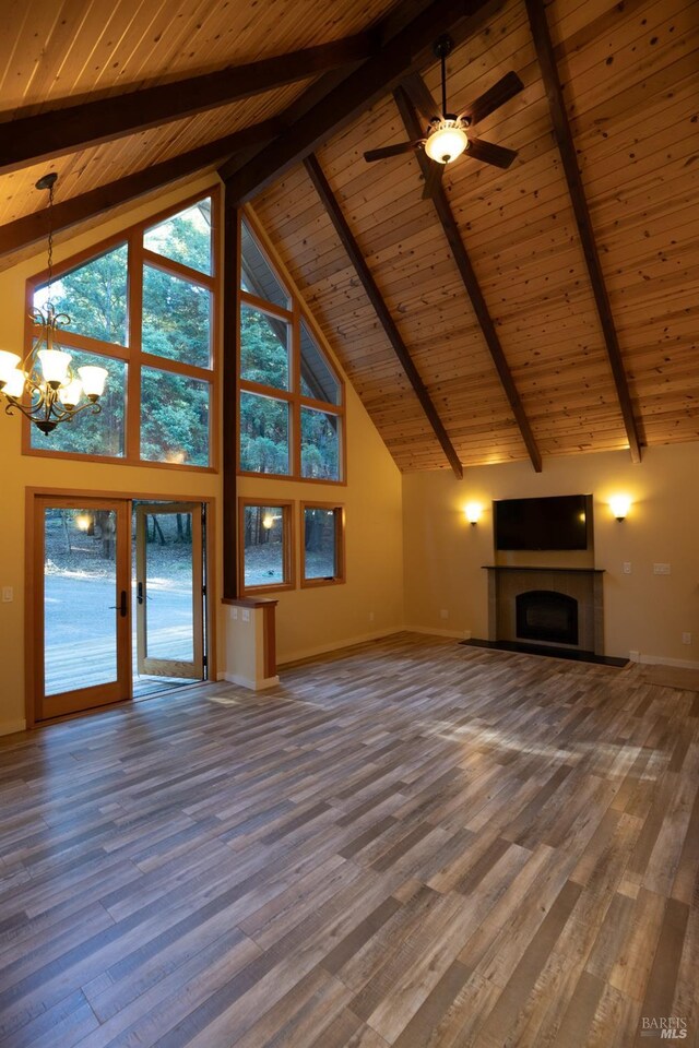 unfurnished living room featuring beamed ceiling, a wealth of natural light, high vaulted ceiling, and wood ceiling