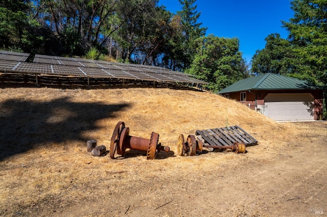 view of yard with a garage and an outbuilding