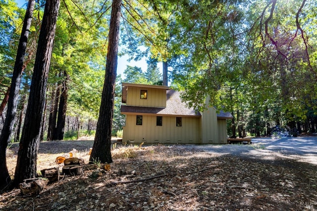 view of home's exterior with a shingled roof and crawl space