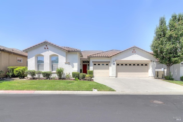 mediterranean / spanish home with a garage and a front yard