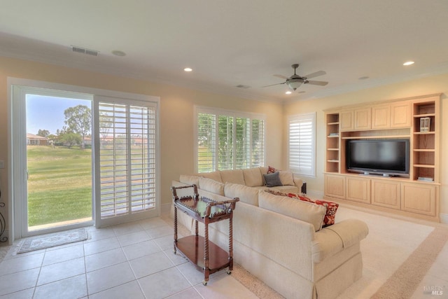 living room with crown molding, ceiling fan, and light tile patterned flooring