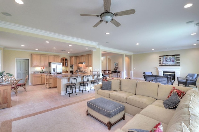 living room featuring ornamental molding, light tile patterned floors, and ceiling fan