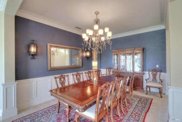 tiled dining room featuring ornamental molding and a chandelier