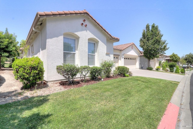 mediterranean / spanish house featuring a garage and a front lawn