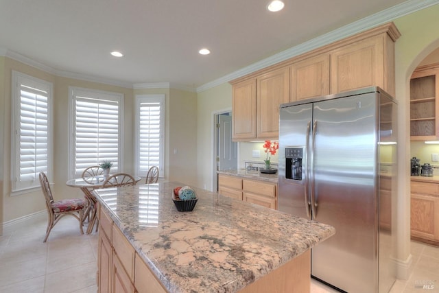 kitchen with a kitchen island, light brown cabinetry, ornamental molding, stainless steel refrigerator with ice dispenser, and light stone countertops