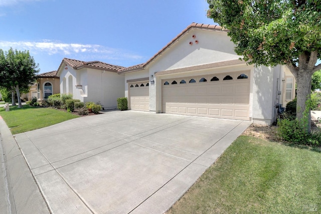 mediterranean / spanish-style house with a garage and a front yard