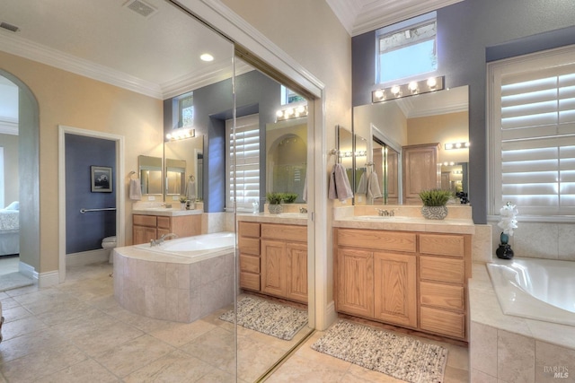 bathroom with ornamental molding, tiled bath, and vanity