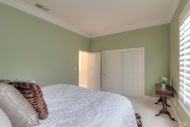 carpeted bedroom with ornamental molding and a closet