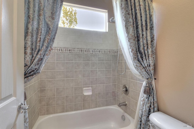 bathroom featuring shower / bathtub combination with curtain and toilet