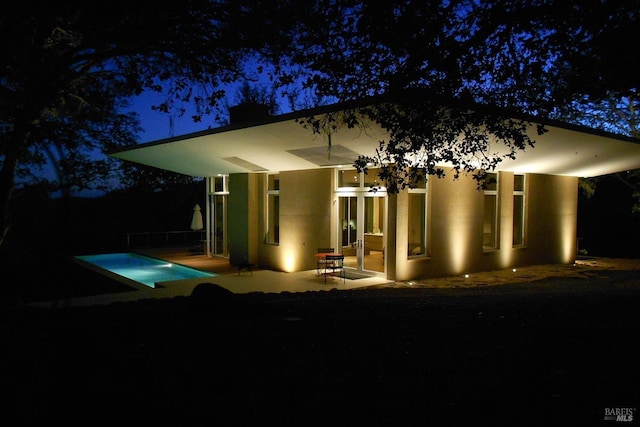 view of front of property with a patio area and an outdoor pool