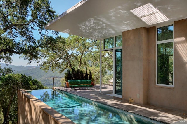 pool with a patio area and a mountain view
