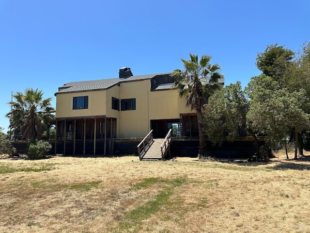 rear view of property featuring a sunroom