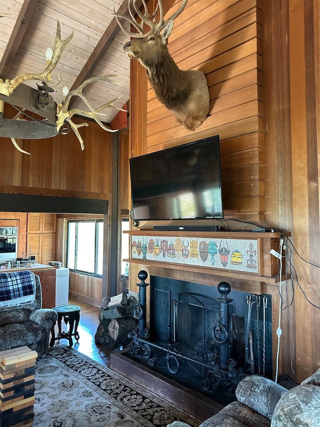 living room with wood ceiling, wooden walls, lofted ceiling, and a wood stove