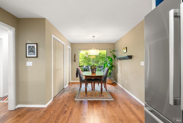 dining space with baseboards and wood finished floors