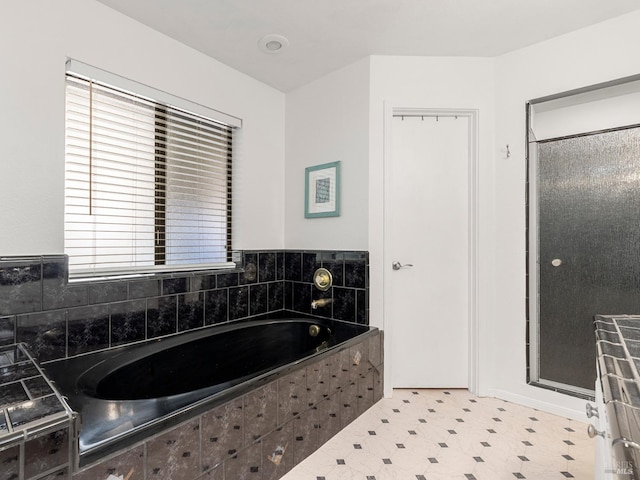 bathroom with a garden tub, a shower stall, and tile patterned floors