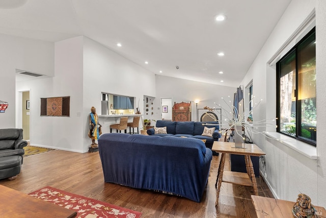 living room with recessed lighting, visible vents, vaulted ceiling, and wood finished floors