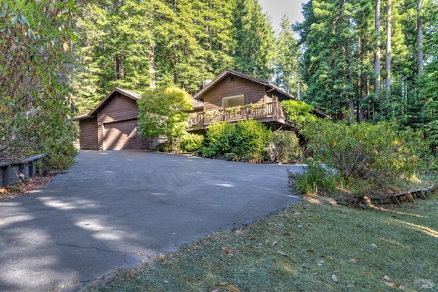 rustic home with a detached garage and a deck