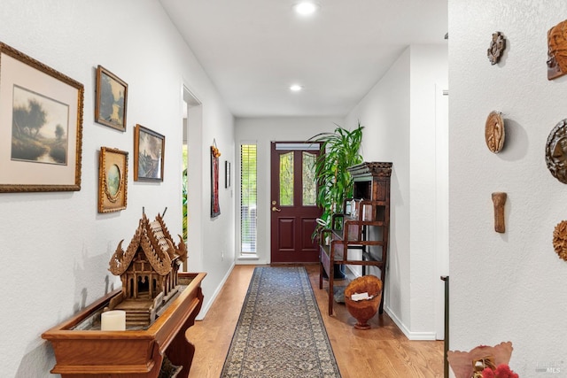 foyer entrance with light wood-style floors, recessed lighting, and baseboards