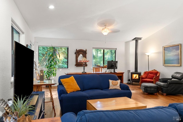 living room featuring wood finished floors, a wood stove, and recessed lighting