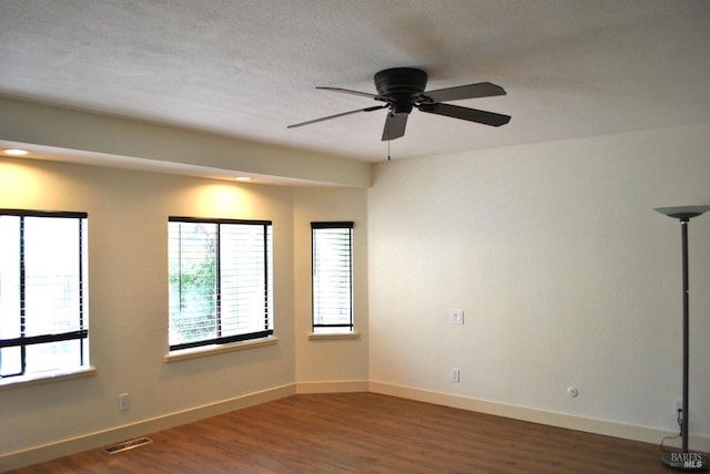 spare room featuring ceiling fan and dark wood-type flooring