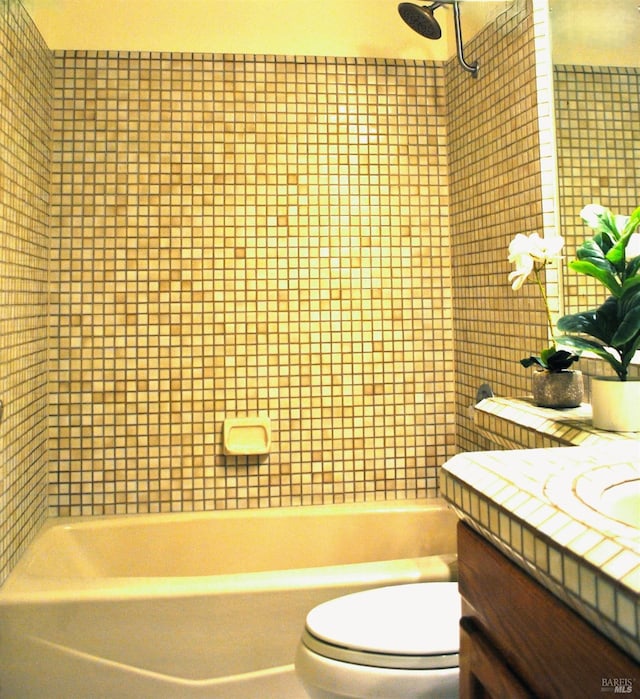 full bathroom featuring vanity, toilet, and tiled shower / bath