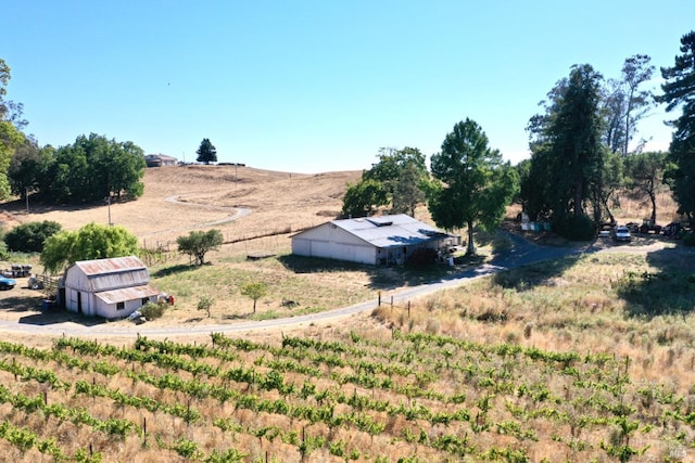 view of yard featuring an outbuilding, a pole building, a rural view, and a barn