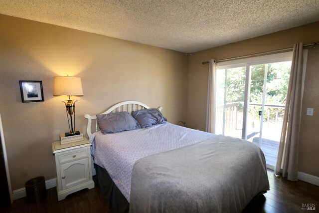 bedroom featuring access to outside, baseboards, dark wood finished floors, and a textured ceiling