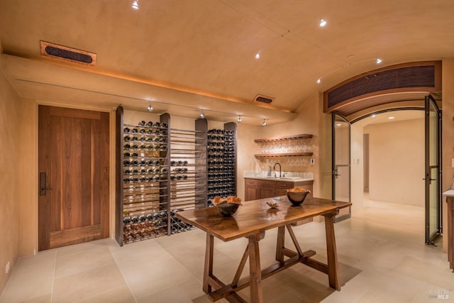 11080 Franz Valley Rd, Calistoga, CA 94515 - wine area with visible vents, a sink, light tile patterned floors, and lofted ceiling