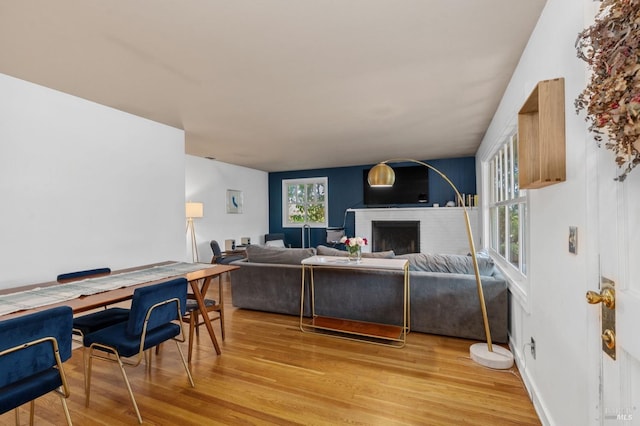 living room featuring a brick fireplace and light hardwood / wood-style floors