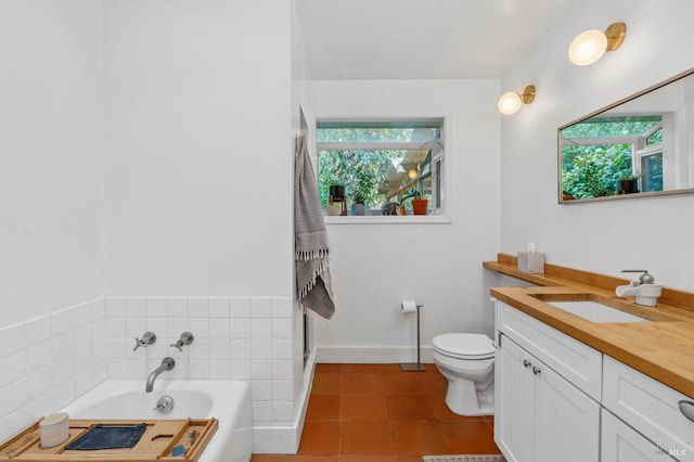 bathroom featuring tile patterned flooring, vanity, toilet, and a tub to relax in