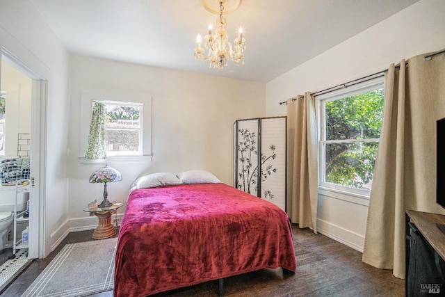 bedroom with a notable chandelier, dark wood-type flooring, and multiple windows