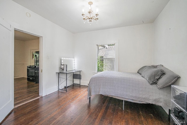 bedroom with a chandelier and dark wood-type flooring