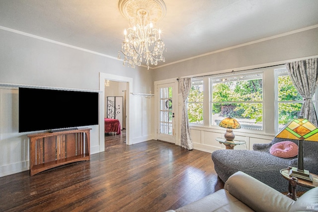 living room with ornamental molding, dark wood-type flooring, and a notable chandelier