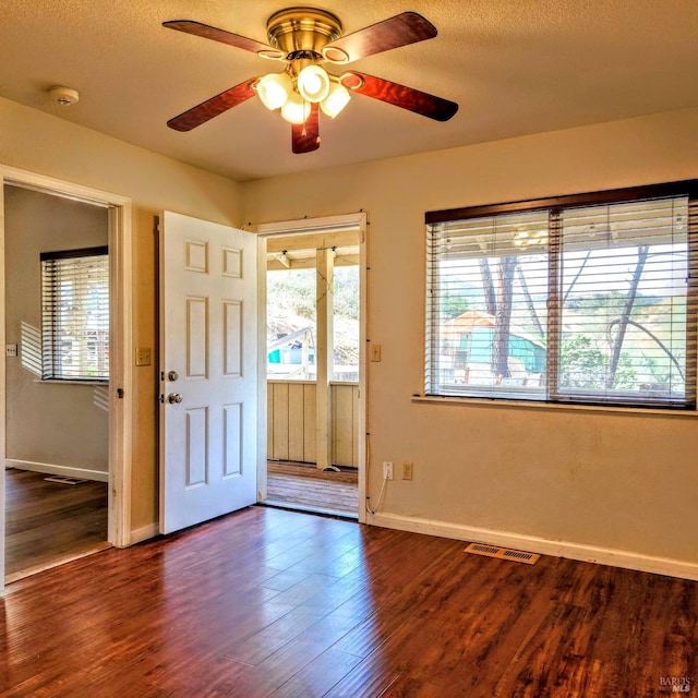 entrance foyer featuring a textured ceiling, dark hardwood / wood-style flooring, and ceiling fan