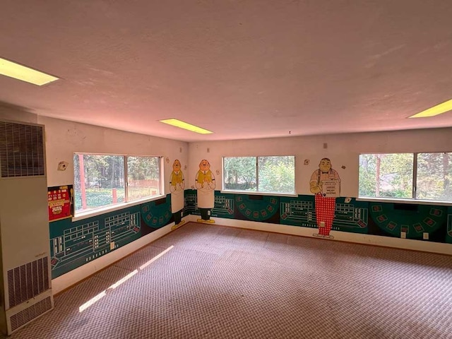 unfurnished room featuring carpet, a wealth of natural light, and lofted ceiling