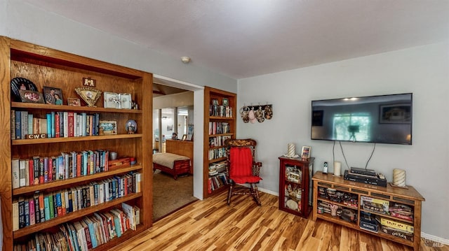 living area featuring baseboards and wood finished floors