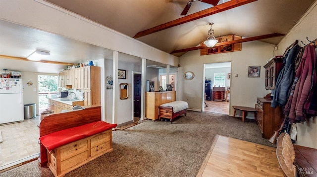 carpeted living room featuring sink and vaulted ceiling with beams