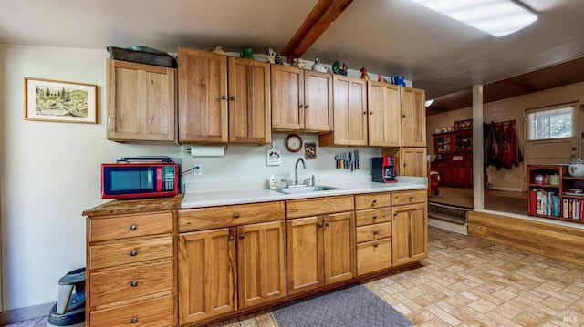 kitchen featuring a sink, light countertops, and brick patterned floor